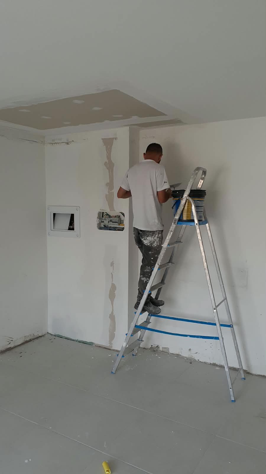 Profissional corrigindo imperfeições da parede antes da pintura