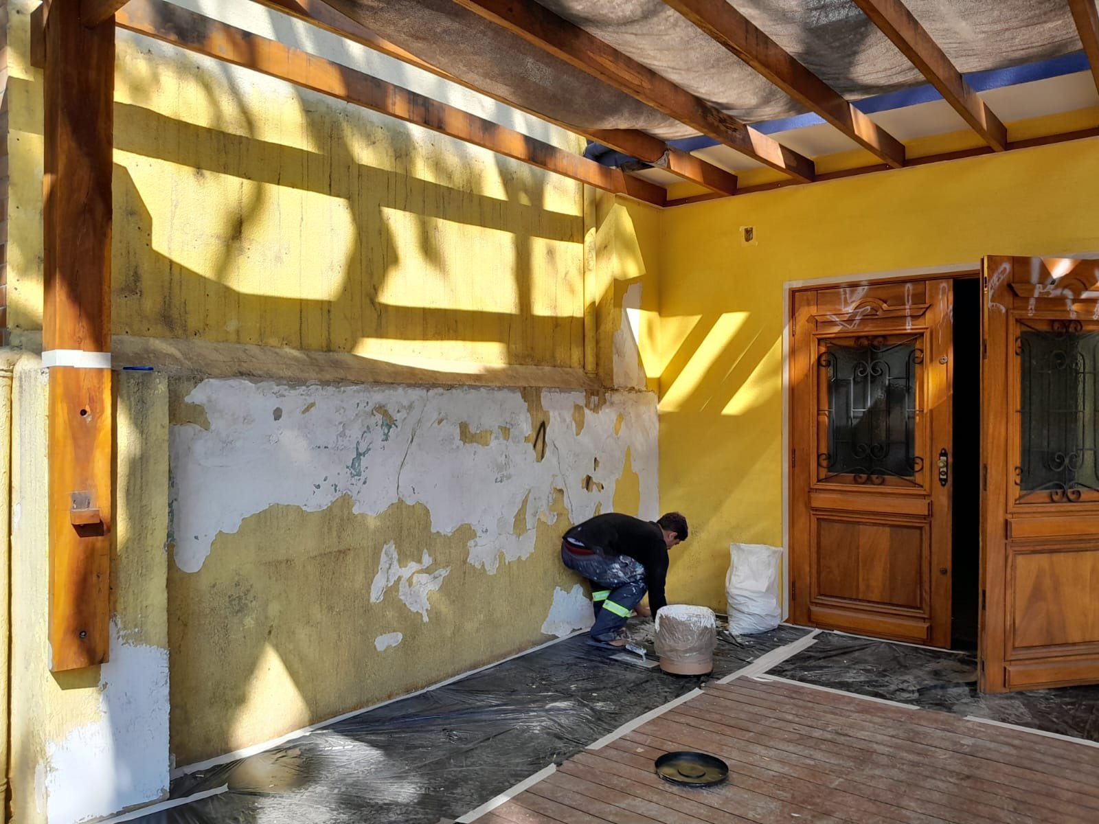 Profissional preparando a fachada de uma loja para repintura